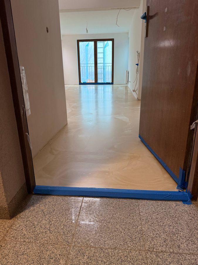 Sypialnia z szarą posadzką żywiczną